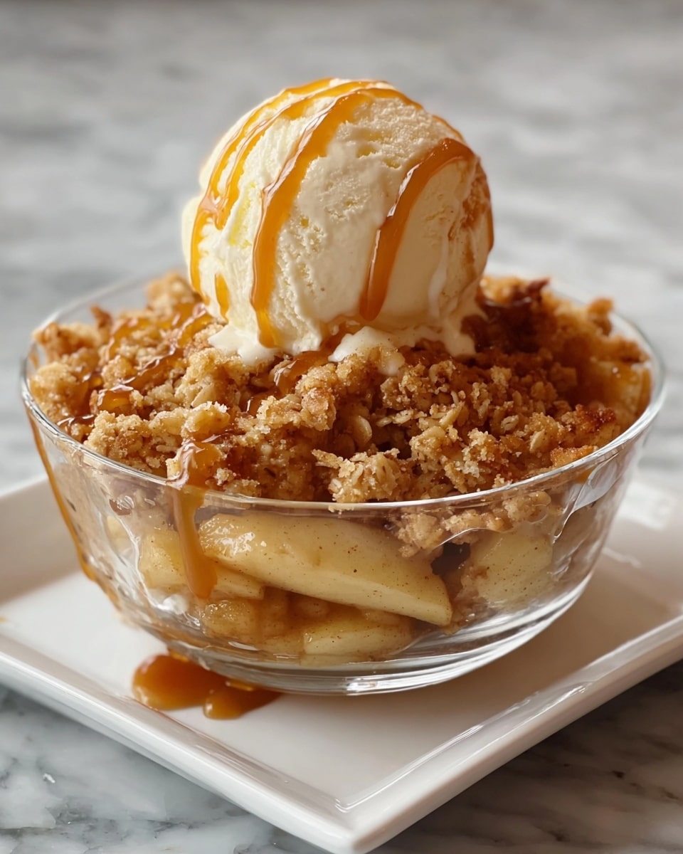 A clear bowl holds a warm apple crumble dessert, with a base layer of chunky, tender apple pieces mixed with a caramel-like syrup, covered by a thick, crumbly topping made of golden brown oats and cinnamon spices. On top, there is a large, smooth scoop of vanilla ice cream with a creamy texture, drizzled with golden caramel sauce that flows gently over the ice cream’s surface. The bowl sits on a white square plate, all placed on a white marbled textured surface. Photo taken with an iphone --ar 4:5 --v 7