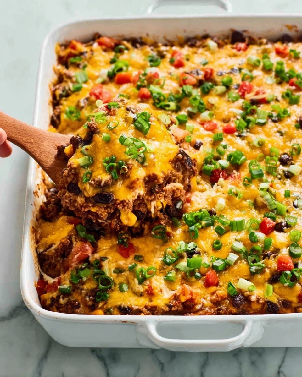 The image shows a rectangular white baking dish filled with a layered casserole. The bottom layer is dark brown, likely ground meat or beans, with a slightly chunky texture. Above it is a layer of melted yellow cheese, smooth and gooey, covering the dish evenly. On top of the cheese, there are scattered small pieces of red and green vegetables, adding bright colors. A wooden spoon is lifting a portion of the casserole, showing all layers clearly. The dish sits on a white marbled surface with a yellow cloth beside it. Photo taken with an iphone --ar 4:5 --v 7