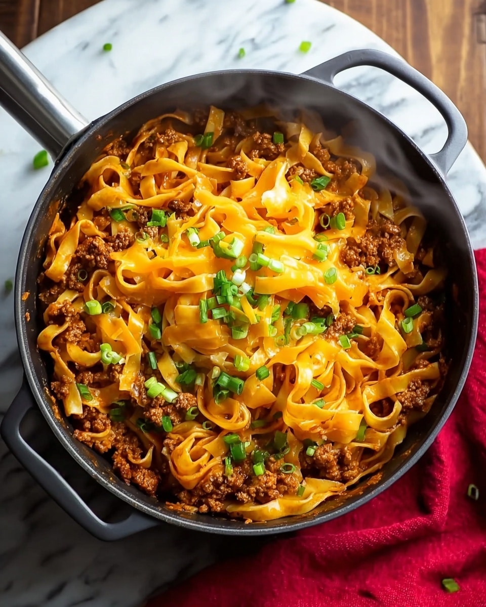 A black pot filled with thick flat noodles covered in melted bright orange cheese, mixed with small chunks of browned ground meat scattered evenly throughout. On top, there is a generous layer of fresh green chopped scallions adding a pop of color. Light steam rises from the hot dish, showing it is freshly cooked. The pot is set on a wooden surface with a red cloth visible on the right side. photo taken with an iphone --ar 4:5 --v 7