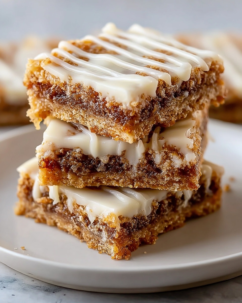 A stack of three square dessert bars sits on a white plate with a thin brown rim, placed on a white marbled surface. Each bar has three visible layers: a bottom layer of crumbly golden-brown crust, a thick middle layer of sticky dark brown filling with bits of nuts, and a top creamy white layer with a smooth texture decorated with thin, wavy lines of white icing drizzled across. The bars are stacked unevenly, showing the rich, gooey filling and crumbly crust clearly with some crumbs scattered around the plate. photo taken with an iphone --ar 4:5 --v 7